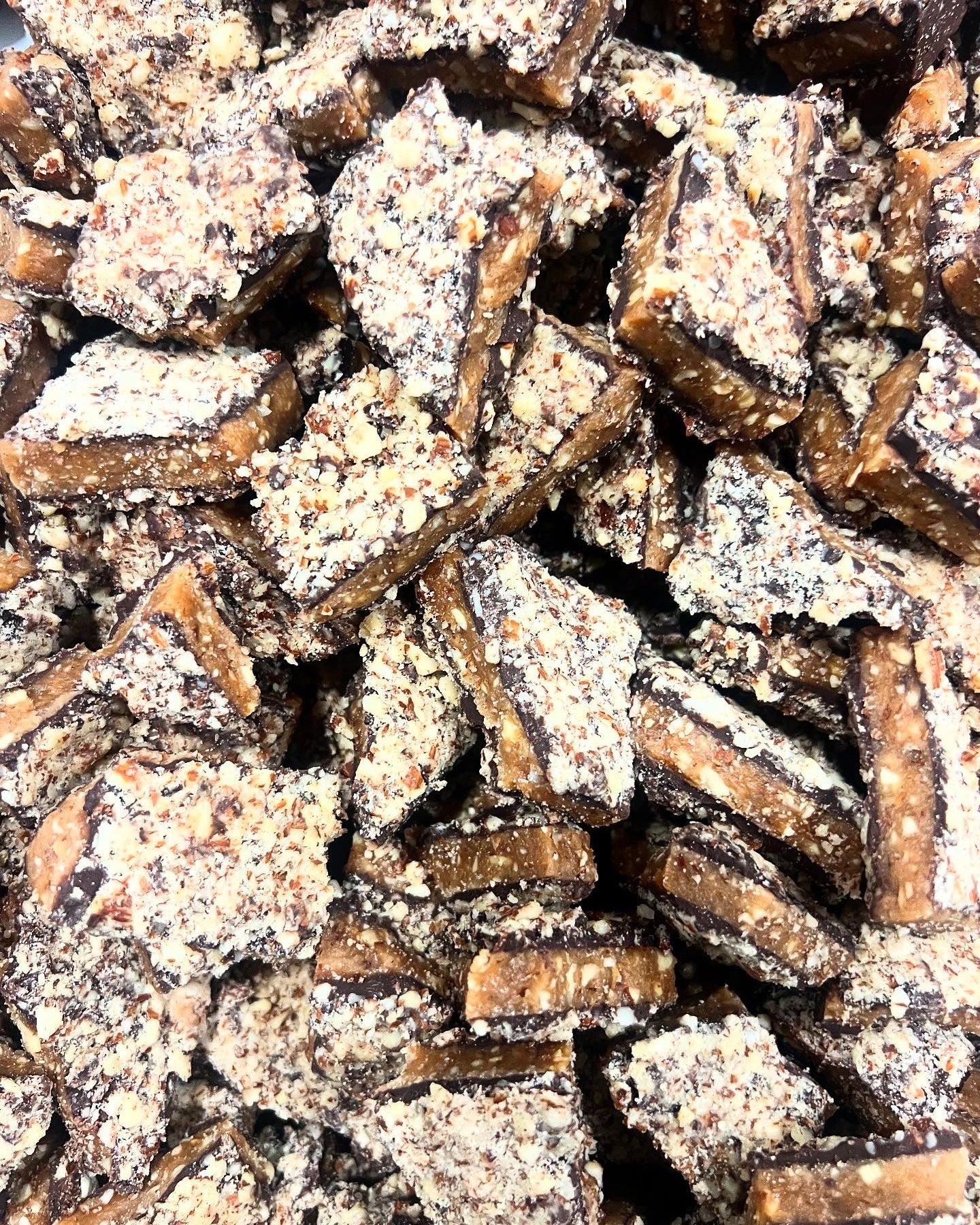 close up of dark chocolate coated toffee with almnonds